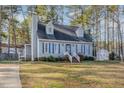 Charming blue two-story home with dormers, blue shutters, an outbuilding, and mature trees at 104 Tyser Pl, Garner, NC 27529