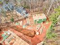 Aerial view showing a house under construction with lumber piles and trusses on a wooded lot at 105 Sherwood Ln, Hillsborough, NC 27278
