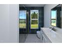 Bright bathroom featuring a walk-in shower, modern vanity, and a window with view to the outdoors at 105 Sherwood Ln, Hillsborough, NC 27278