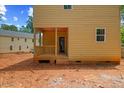 View of the two-story home's rear covered porch and light yellow exterior paint at 105 Sherwood Ln, Hillsborough, NC 27278