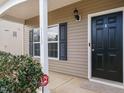 Inviting front porch featuring a black door, black shutters, and manicured landscaping at 1113 Crendall Way, Wake Forest, NC 27587