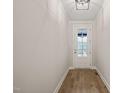 Bright hallway with wood-look floors leads to a front door with glass and a modern ceiling light at 140 Pilot Ridge Rd, Zebulon, NC 27597
