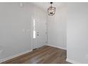Inviting entryway with hardwood floors, fresh paint, and modern light fixture at 203 Frosted Iris Lane St # 181, Garner, NC 27529