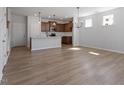Open-concept living room with hardwood floors, modern light fixture, and lots of natural light at 203 Frosted Iris Lane St # 181, Garner, NC 27529