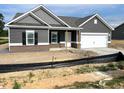 Charming single-Gathering home with gray siding, white trim, a covered porch, and a two-car garage at 316 Olivia Crossing Ct # 11, Four Oaks, NC 27524
