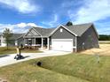 New construction, single-story home with an attached garage and freshly laid sod at 316 Olivia Crossing Ct # 11, Four Oaks, NC 27524