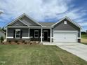 Beautiful single-story home with gray siding, white trim, a two-car garage, and green lawn at 316 Olivia Crossing Ct # 11, Four Oaks, NC 27524