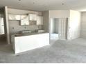 Unfinished kitchen featuring white cabinets, an island, and an open concept layout, ready for personalization at 316 Olivia Crossing Ct # 11, Four Oaks, NC 27524