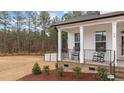 Inviting front porch features black rocking chairs, white columns, and brick accents, perfect for relaxing outdoors at 40 Long Needle Ct, Youngsville, NC 27596