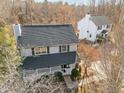 Aerial view of the house showcasing its black roof, landscaping, and proximity to surrounding trees at 4319 White Cliff Ln, Durham, NC 27712