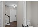 Welcoming foyer with hardwood floors, a staircase, and a half bathroom, creating an inviting entry at 4319 White Cliff Ln, Durham, NC 27712