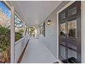 Inviting covered front porch with a freshly painted floor and a stylish black front door with glass inserts at 4319 White Cliff Ln, Durham, NC 27712