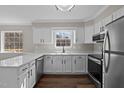 Bright kitchen with white cabinetry, modern stainless steel appliances, and wood flooring at 4319 White Cliff Ln, Durham, NC 27712