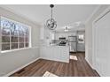 Eat-in kitchen featuring stainless steel appliances, white cabinets, and contemporary light fixture at 4319 White Cliff Ln, Durham, NC 27712
