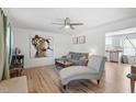 Bright living room with hardwood floors, modern ceiling fan, and gray furniture at 506 W Gilbreath St, Graham, NC 27253