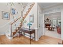 Inviting foyer with hardwood floors, staircase, and view of the living room fireplace at 5309 Shoreline Ct, Holly Springs, NC 27540
