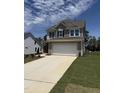 Two-story home with gray siding, a two-car garage, and a concrete driveway surrounded by a green lawn at 542 Winding Crk Dr, Lillington, NC 27546