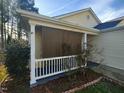 View of the home's charming screen porch with neutral facade and manicured garden bed at 5836 Bryanstone Pl, Raleigh, NC 27610