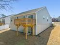 View of a home's back exterior showing a walkout basement and an elevated wood deck at 612 Jasmine St, Wendell, NC 27591