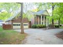 A beautiful two-story brick home with white columns, a two-car garage, and a spacious driveway at 826 Warwick Ct, Burlington, NC 27215