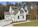A spacious white home showcasing a two car garage, board and batten siding, and well-manicured lawn at 842 Magnolia Acres Ln, Fuquay Varina, NC 27526
