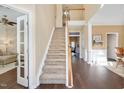 Spacious foyer with hardwood floors, staircase, and views to living areas at 104 Spooner Ct, Holly Springs, NC 27540