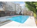 Backyard features a refreshing in-ground pool, diving board, lounge chairs, and an upper-level deck at 104 Spooner Ct, Holly Springs, NC 27540