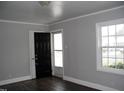 Bright living room featuring sleek, dark flooring, fresh paint, and natural light through a window at 105 S Elizabeth St, Henderson, NC 27536
