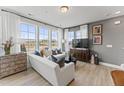 Sun-filled living room with hardwood floors, large windows offering scenic views, and comfortable seating with stylish decor at 10529 Pleasant Branch Dr # 101, Raleigh, NC 27614