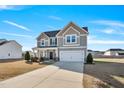 Beautiful two-story home with a two-car garage, gray siding, and a well-maintained lawn on a sunny day at 109 Perignon Dr, Princeton, NC 27569