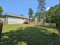 Large fenced-in backyard featuring a spacious lawn and a wooden deck, perfect for outdoor enjoyment at 1212 E Middleton Dr, Creedmoor, NC 27522