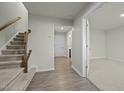 Inviting entryway with hardwood floors, a staircase with wooden banister, and a view into a carpeted room at 1414 Excelsior Grand Ave, Durham, NC 27713