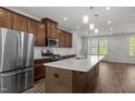 Bright kitchen with a stainless steel refrigerator, center island, and modern fixtures at 1414 Excelsior Grand Ave, Durham, NC 27713