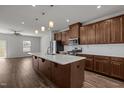 Modern kitchen featuring a center island, stainless steel appliances, and rich brown cabinetry at 1414 Excelsior Grand Ave, Durham, NC 27713