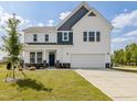 Charming two-story home featuring manicured lawn, attached two car garage, and beautiful white siding at 144 Sugar Pine Drive, Franklinton, NC 27525