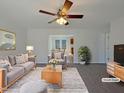 Bright living room boasts a ceiling fan and flows into the dining area, perfect for gatherings at 207 Lawrence St, Fuquay Varina, NC 27526