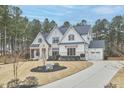 Beautiful two-story home featuring a three-car garage, white siding, brick accents, and a well-maintained yard at 240 Seaforth Landing Dr, Pittsboro, NC 27312