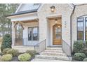 Inviting front porch with stone steps, brick accents, and a decorative glass front door with sidelights at 240 Seaforth Landing Dr, Pittsboro, NC 27312