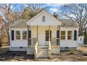Cozy home with a welcoming porch, updated concrete stairs, and stylish black shutters at 2504 E East Geer St, Durham, NC 27704