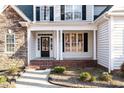 Welcoming front porch featuring brick steps, white columns, and a decorative wreath on the door at 2600 Buckingham Dr, Sanford, NC 27330