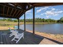 Picturesque covered dock view with white Adirondack chairs overlooking the serene lake at 2609 Pleasant Hill Liberty Rd, Liberty, NC 27298