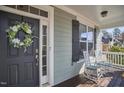 Covered porch features two rocking chairs, dark shutters, and decorative front door with wreath at 2745 Cutleaf Dr, Apex, NC 27539