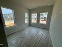 Bright bedroom with three large windows offering ample natural light and neighborhood views during construction at 304 Chesapeak Commons St # 146, Garner, NC 27529
