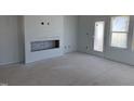 Unfinished living room with fireplace feature, a door, and windows at 304 Chesapeak Commons St # 146, Garner, NC 27529