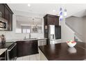 Modern kitchen featuring dark wood cabinets, stainless steel appliances, and a spacious island at 3118 Settle In Ln, Raleigh, NC 27614