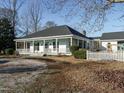 Inviting white home with a porch, ceiling fans, and a well-maintained yard at 4063 Nc-39, Selma, NC 27576