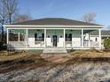 Charming front exterior with a porch and pillars, decorative fans and a black front door at 4063 Nc-39, Selma, NC 27576