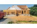 New home construction featuring a framed house with two construction workers on the roof and open blue sky at 409 Grading Stick Ct, Angier, NC 27501