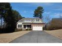 View of a single Gathering home with a well manicured lawn and driveway leading to a 2 car garage at 4305 Albino Deer Way, Wake Forest, NC 27587