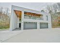 Stunning modern home exterior featuring a three-car garage and sleek architectural design at 4908 Birchleaf Dr, Raleigh, NC 27606